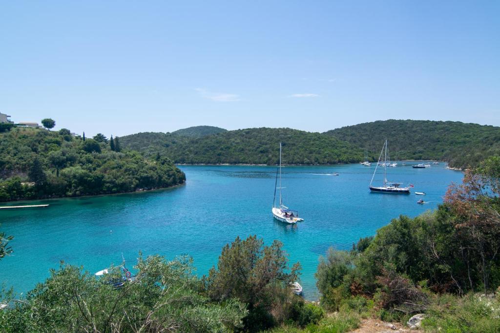 two boats are docked in a large river at Sivota Deamaris Luxury Boutique Hotel in Syvota