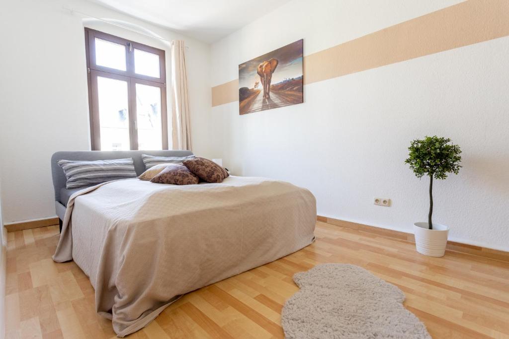 a bedroom with a bed with a teddy bear on it at FULL HOUSE Studios - Apartment Namibia in Chemnitz