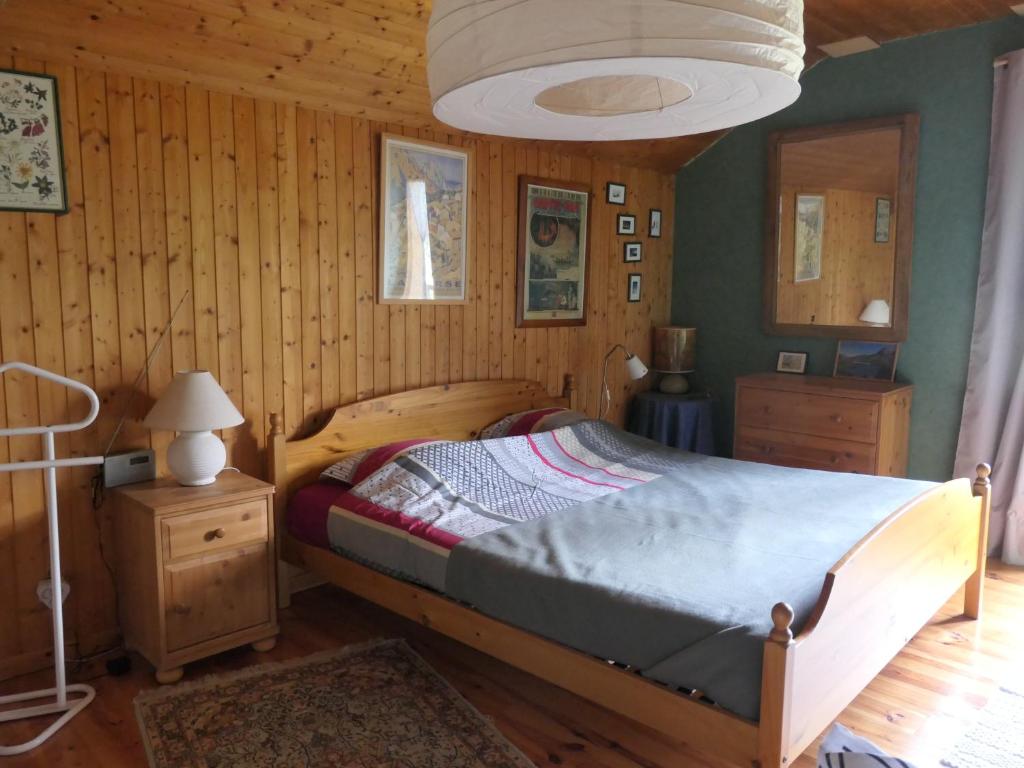 een slaapkamer met een bed in een houten kamer bij Le Ginkgo - Mont Dauphin in Eygliers