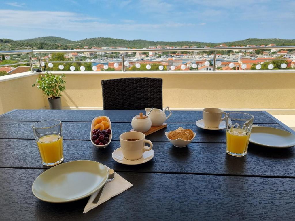 un tavolo con tazze e piatti di cibo su un balcone di Apartment Leona a Jezera