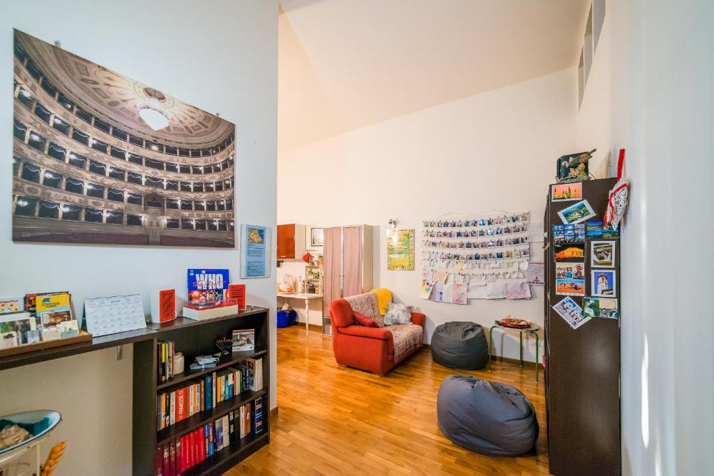 sala de estar con estante de libros y silla en affittacamere Corte Callegari, en Rávena