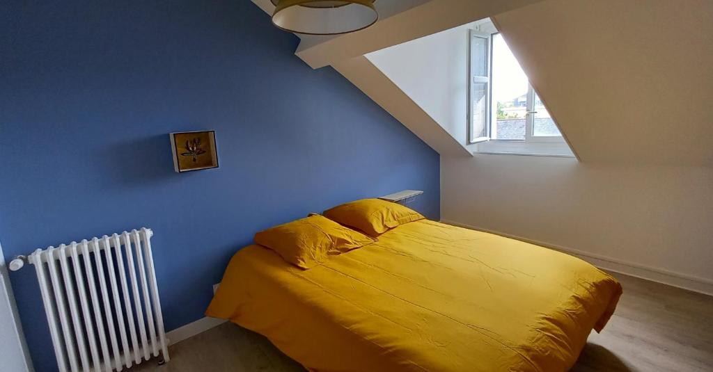 a bedroom with a yellow bed and a window at HISTOIRE DE LOIRE - LA TOUE in Saumur
