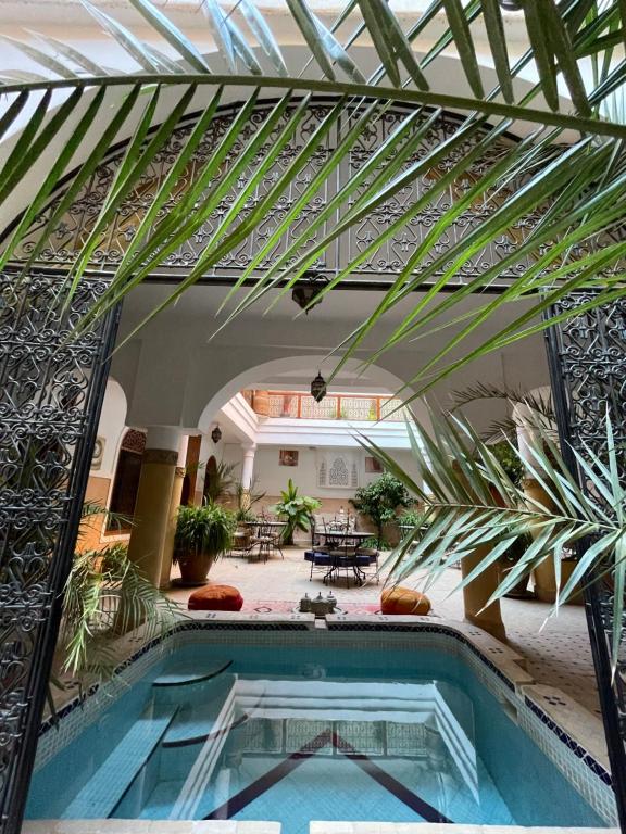 una piscina in una casa con soffitto in vetro di Riad La Calèche & SPA a Marrakech