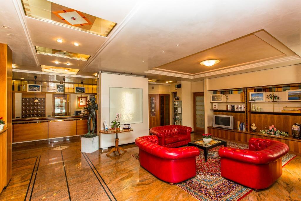 a living room with two red chairs and a table at Hotel Tegorzo in Fener