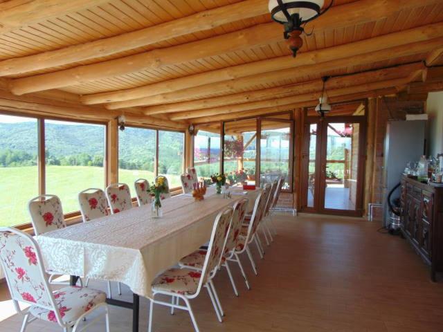ein großes Esszimmer mit einem langen Tisch und Stühlen in der Unterkunft Cabana Foişor 