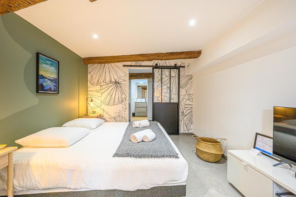 a bedroom with a large white bed and a flat screen tv at LE DREZEN - Cocon tendance au port de Vannes in Vannes