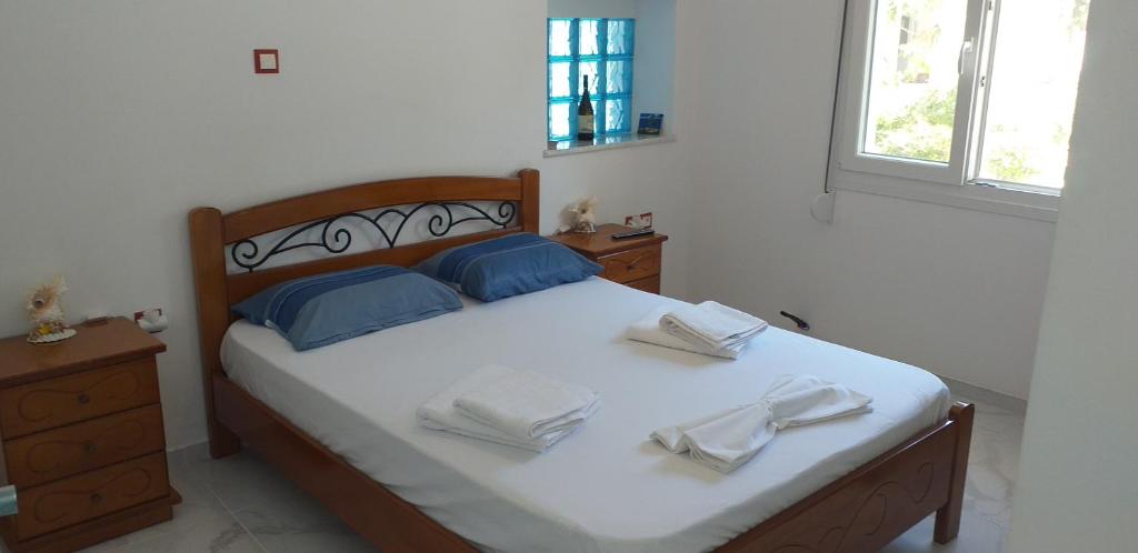 a bedroom with a bed with white sheets and blue pillows at white and blue,finikas syros in Víssa