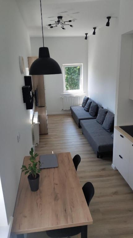 a living room with a wooden table and a couch at Studio 4 Piętro II in Sopot