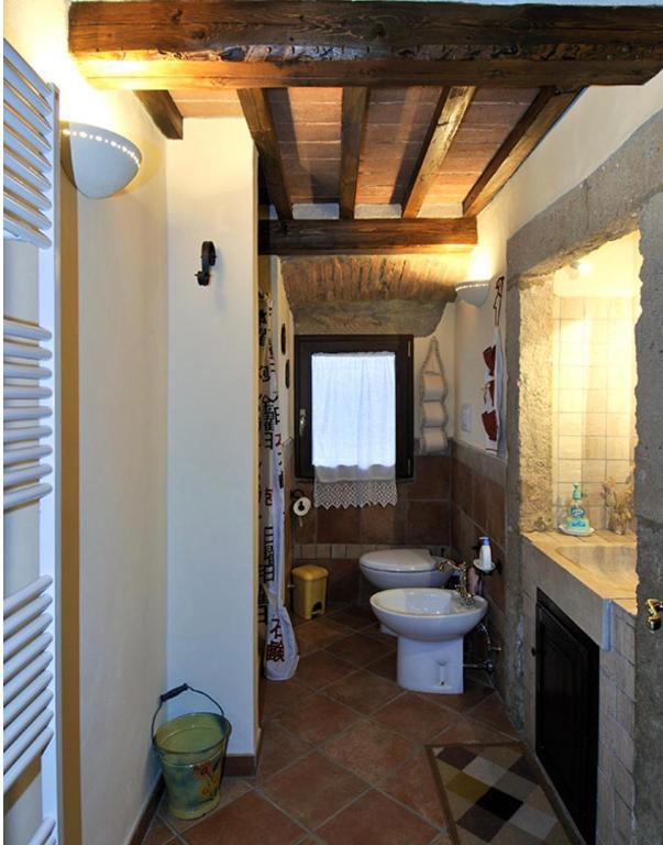 Łazienka z białą toaletą i umywalką w obiekcie Piccola casa toscana con giardino con vista mozzafiato w mieście Podere Cordicella