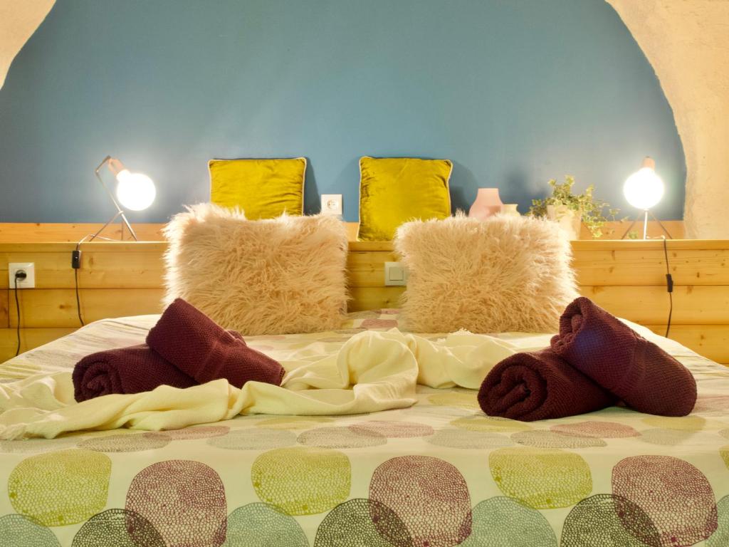 un letto con alcune coperte e cuscini sopra di Chalet d'hôtes Auris ad Auris