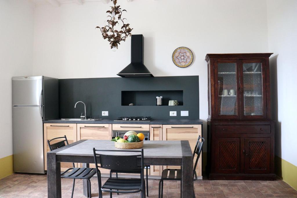 a kitchen with a table with chairs and a refrigerator at Agriturismo Morani in Santa Severa