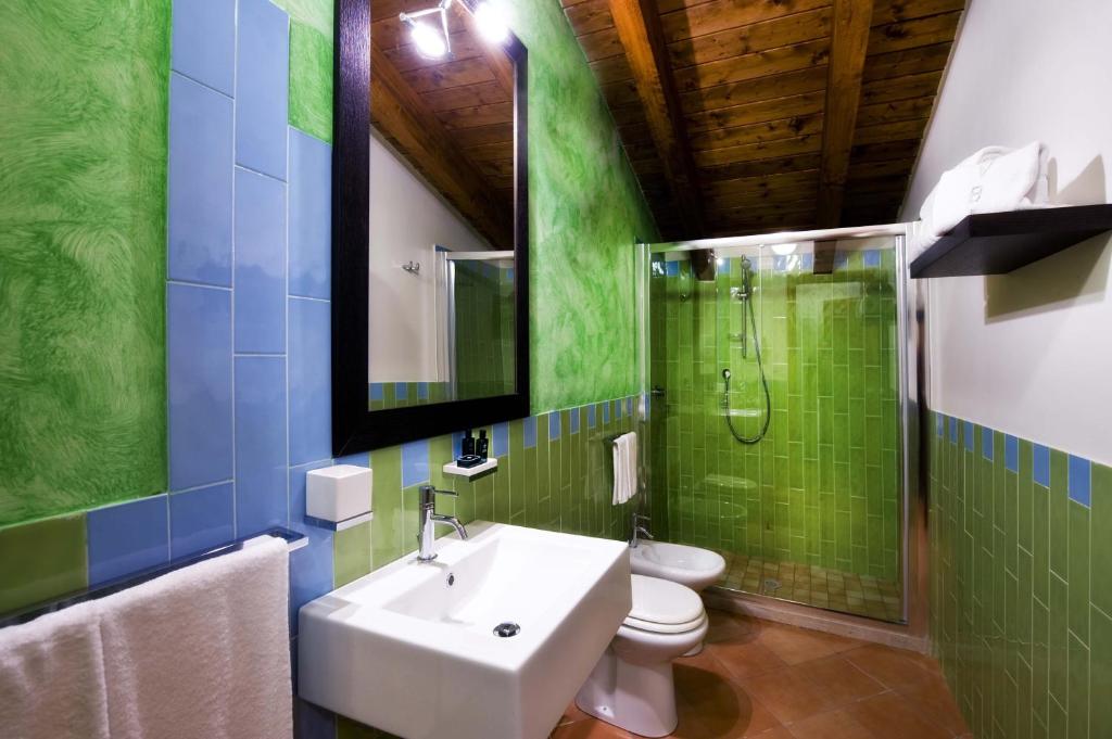a bathroom with a toilet, sink, and mirror at Relais Villa Buonanno in Cercola