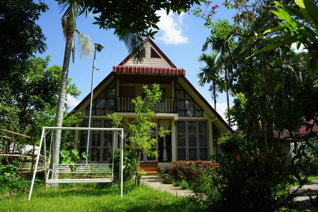 a house in the middle of a garden at SukSanti CoLiving and Vacation in Chiang Rai