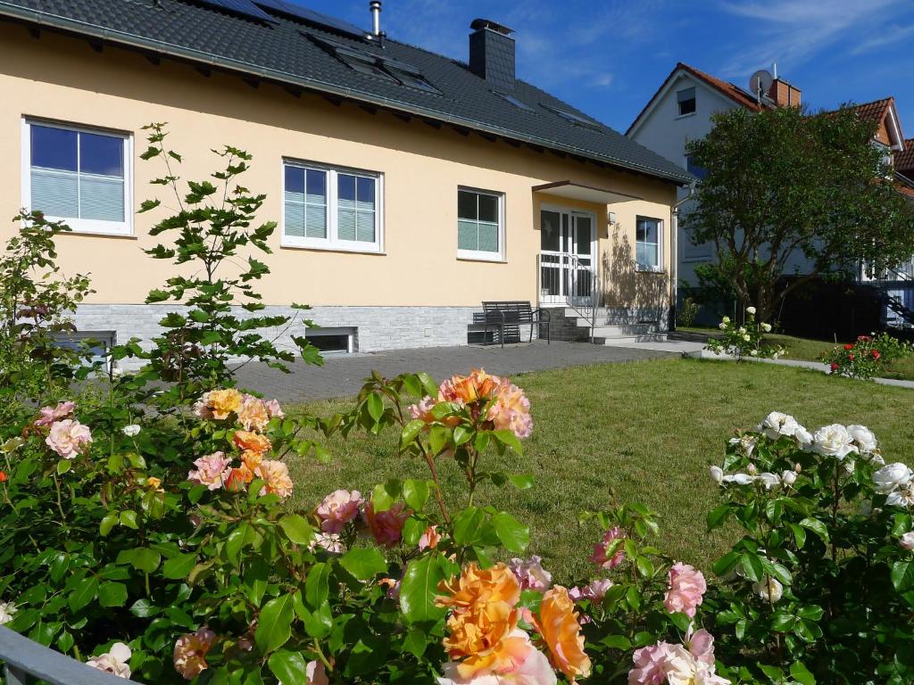 a house with flowers in the front yard at Ferienwohnung mit Terrasse am Rosengarten in Alzenau