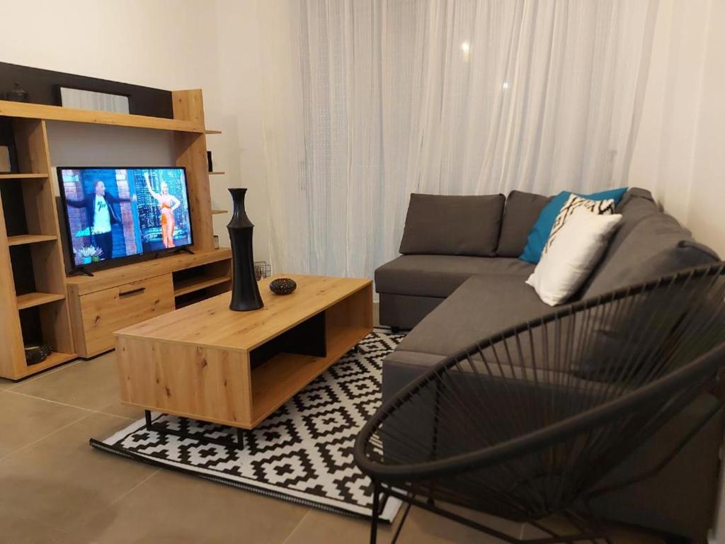 ein Wohnzimmer mit einem Sofa und einem TV in der Unterkunft Valentinas apartment ! in Polis Chrysochous
