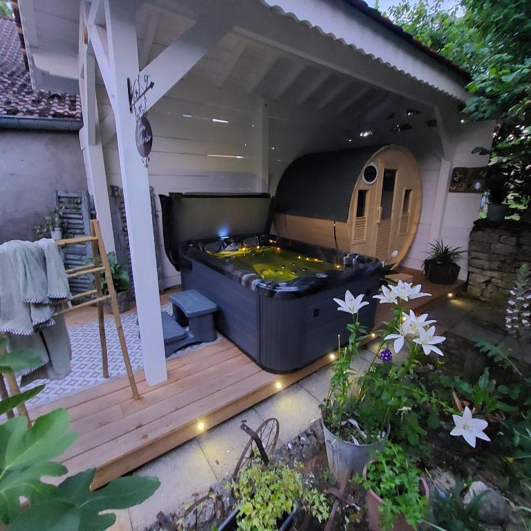 a hot tub on a deck in a backyard at Côté Jardin, Spa privatif 