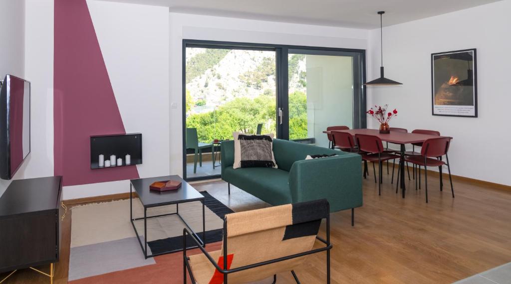 ein Wohnzimmer mit einem grünen Sofa und einem Tisch in der Unterkunft Rivus Apartments in Omiš