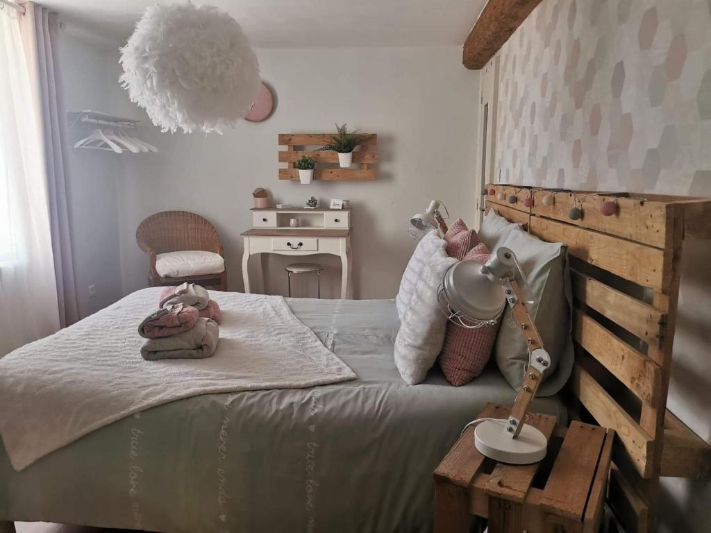 ein Schlafzimmer mit einem Bett mit einer Lampe und einem Tisch in der Unterkunft Chez Stéphane et Patricia in Vertaizon