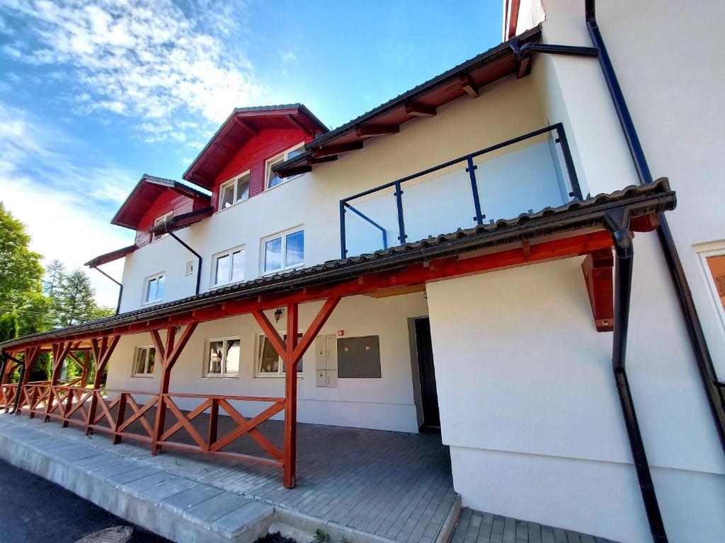 a house with a red and white building at Panoramatický apartmán Tatry in Nová Lesná