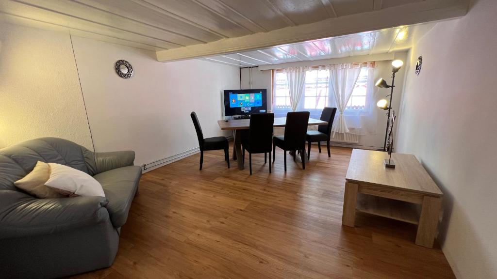 a living room with a couch and a table with chairs at Esencial Apartment Interlaken in Interlaken