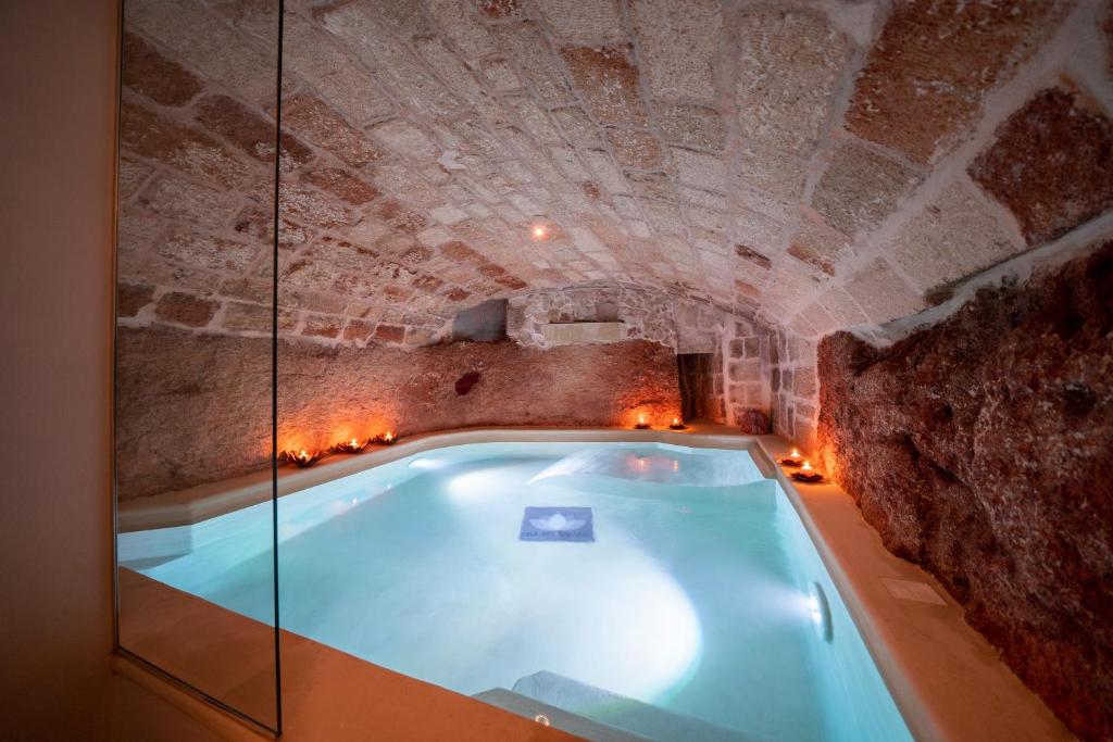 ポリニャーノ・ア・マーレにあるDimora Valmar Luxury Charmの石壁の洞窟内のホットタブ