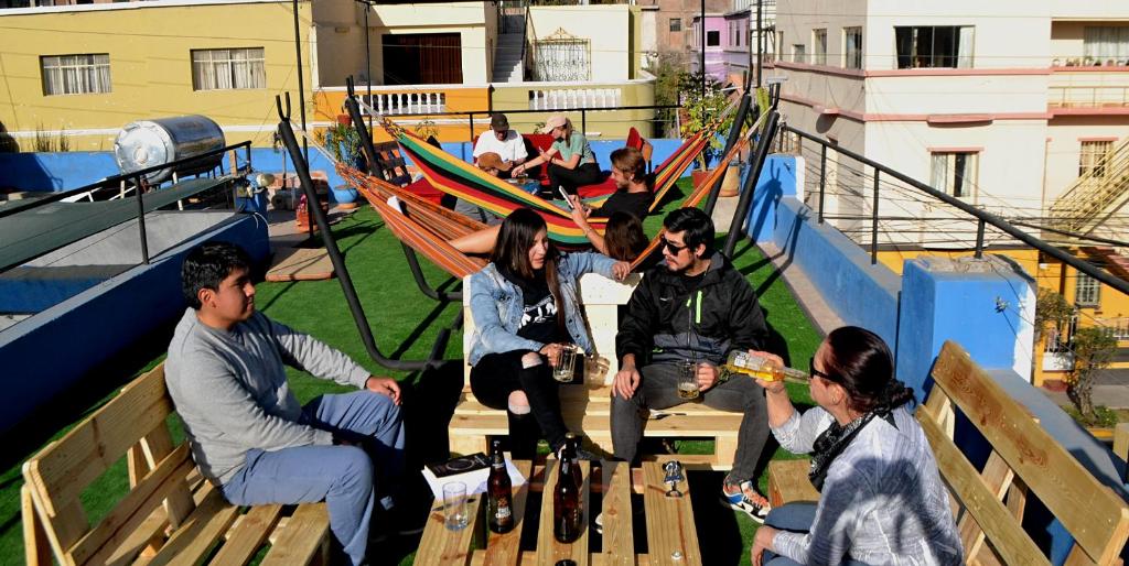 a group of people sitting on benches in hammocks at Econunay Hostels in Arequipa