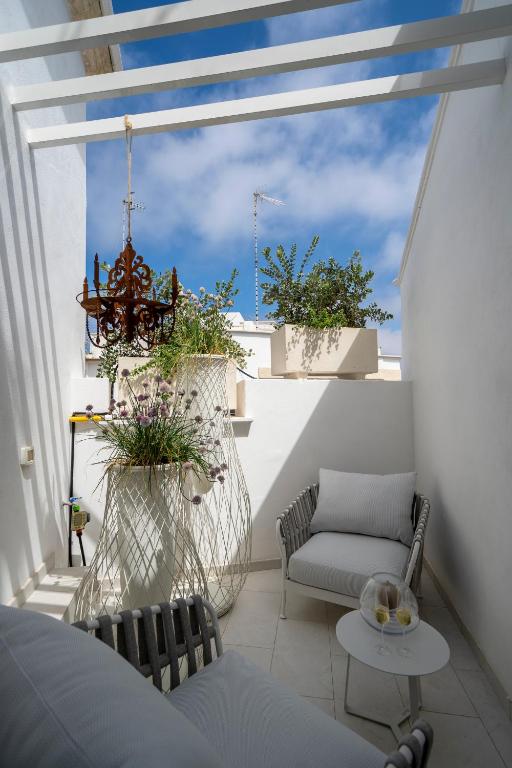 a balcony with two chairs and a chandelier at New Dimora Valmar in Polignano a Mare