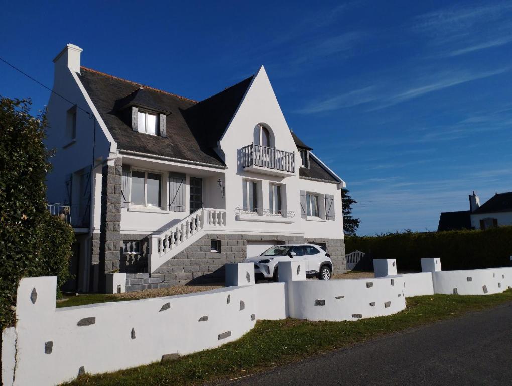 a house with a white fence in front of it at CHAMBRE D'HOTES KER BEL LEUR in Kerlouan