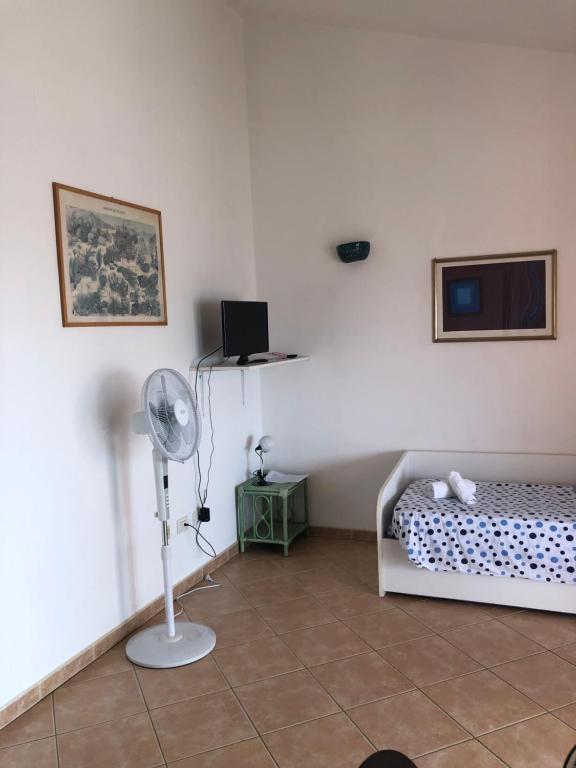 a bedroom with a bed and a fan in a room at Residence Uliveto app 33 Birgalavo' in Agrustos