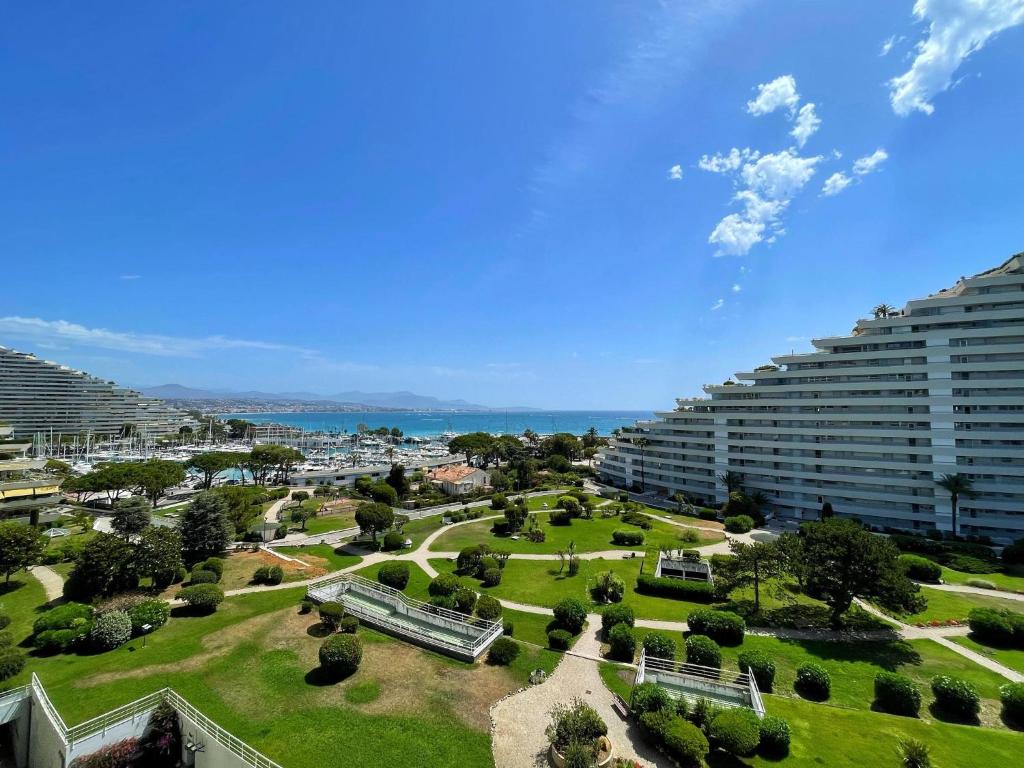 a park in front of two large buildings at #902 MARINA RIVIERA BAY - Marina Baie des Anges in Villeneuve-Loubet