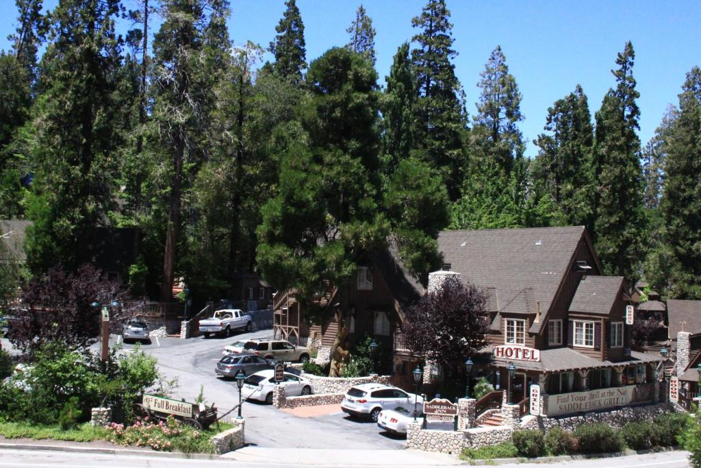 a house with cars parked in a parking lot at Saddleback Inn at Lake Arrowhead in Lake Arrowhead