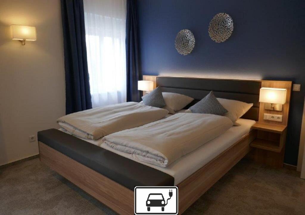 1 dormitorio con 1 cama grande y pared azul en Hotel van Lendt - Ihr Frühstückshotel garni, en Dulmen