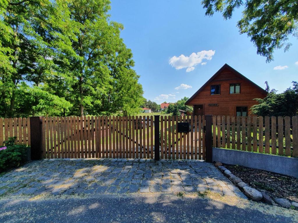 a wooden fence with a gate in front of a house at Anna i Halina in Sztutowo