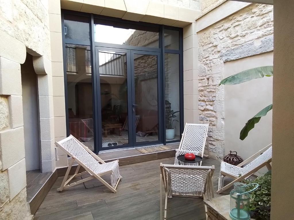 patio z 2 krzesłami i stołem w obiekcie La Barrack Broc w mieście Aimargues