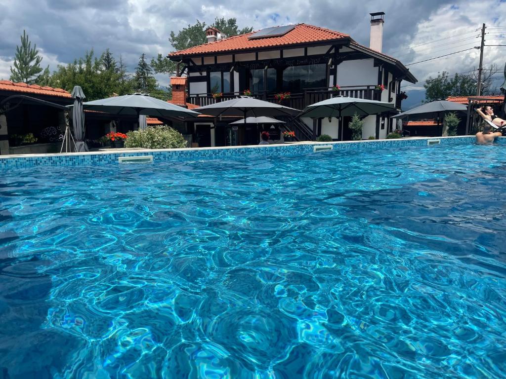 a swimming pool with blue water in front of a building at Seven Springs Hotel in Banya