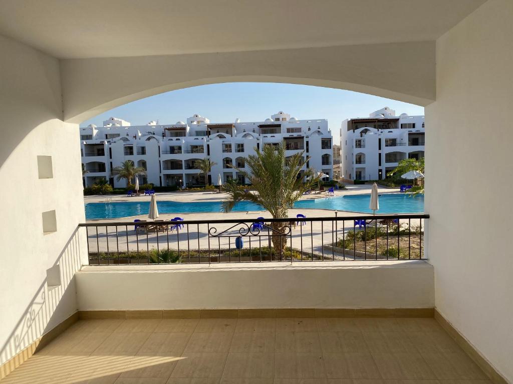 een balkon met uitzicht op een zwembad en gebouwen bij Palmera Resort Ain Sokna - Building No# 32 Flat No# 4 in Suez