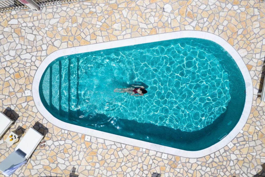 a person swimming in a swimming pool in a tub at Ionian Mansion in Andipáta Erísou