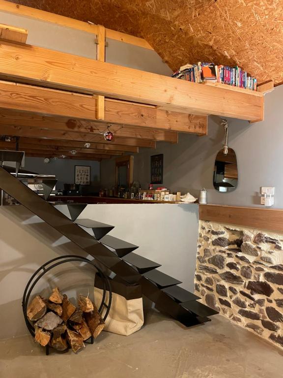 drewniana klatka schodowa w pokoju z kamiennym kominkiem w obiekcie CHALET LA BOLLINE w mieście Valdeblore