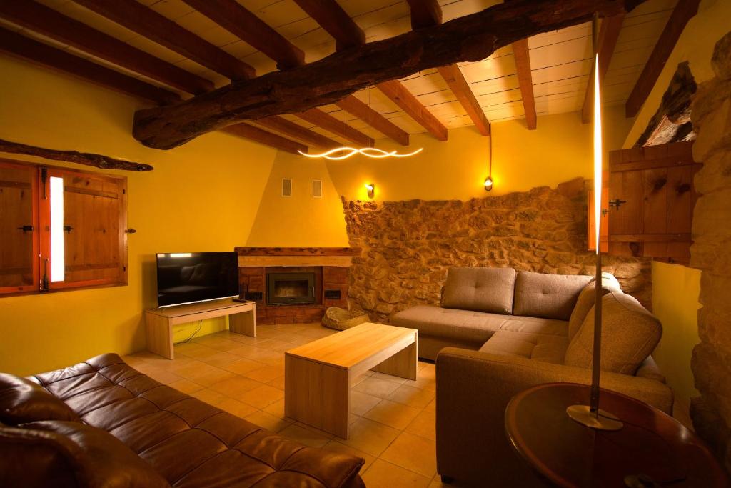 a living room with a couch and a tv at El Cau de Corcolilla (Villa Rural) in Corcolilla