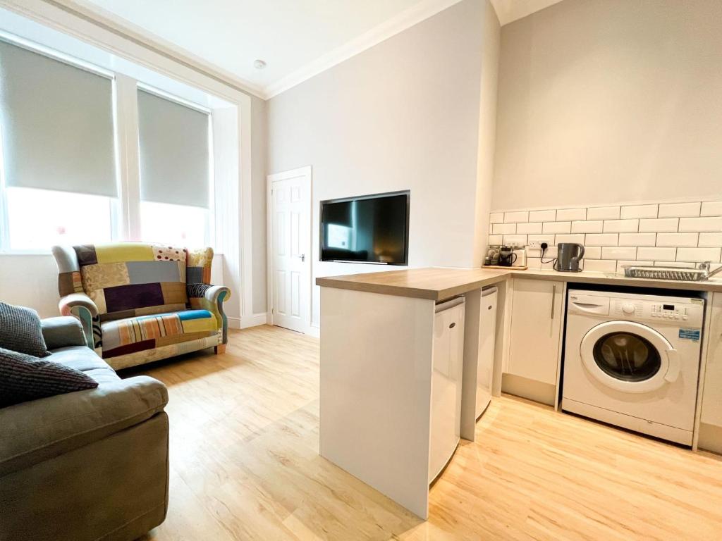 a kitchen and living room with a washer and dryer at 1 Bedroom Glasgow Apartment in Glasgow