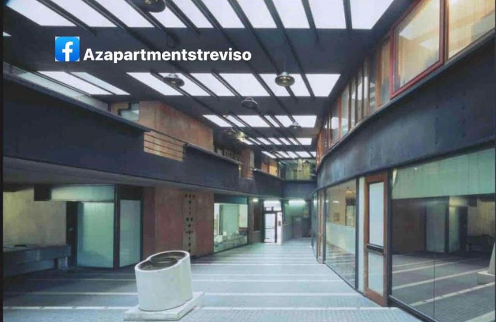 an empty hallway of a building with a sign on the ceiling at Azapartments in Treviso