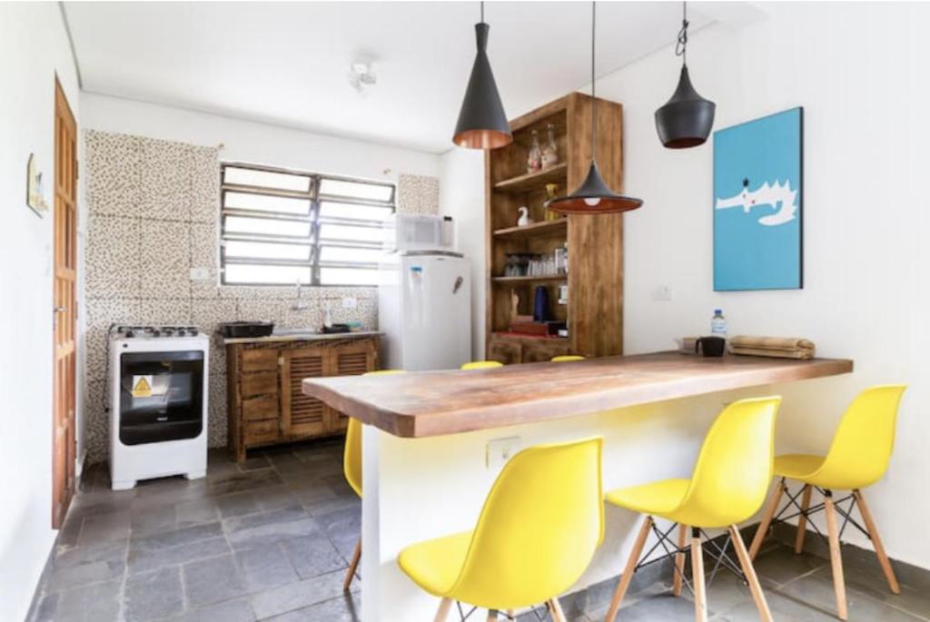 uma cozinha com cadeiras amarelas e uma ilha de cozinha em Casa Litoral Sul de São Paulo, Peruibe em Itariri