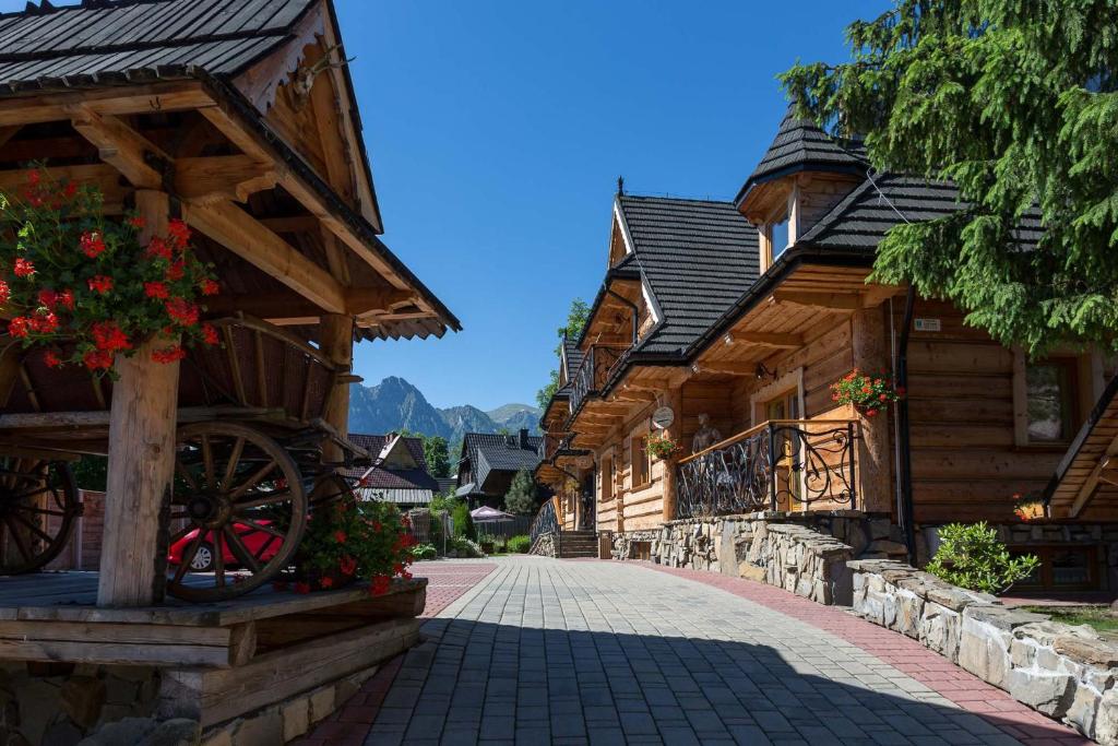 a cobblestone street in front of wooden buildings at Hotel Bambi Boutique in Zakopane