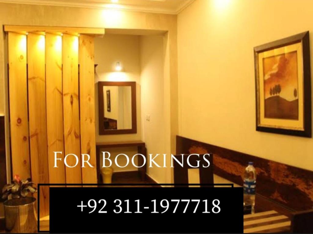 a sign that reads for bookings in a room at The Corner Inn Guest House in Karachi