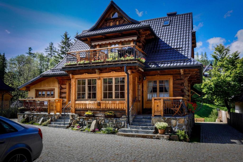 une grande maison en bois avec un toit en gambrel dans l'établissement Bambi Cottage, à Zakopane