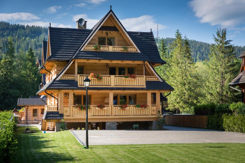 a large wooden house with a gambrel roof at Aparthotel Bambi in Zakopane