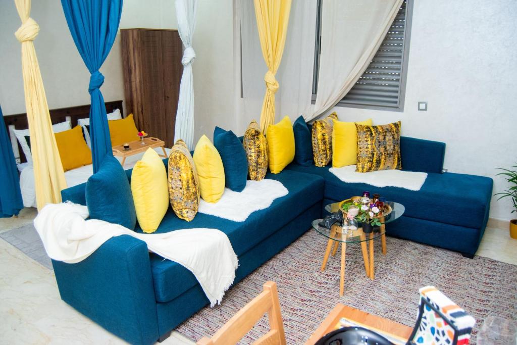 een blauwe bank met gele kussens in de woonkamer bij Studio Cozy Parc Mohammedia in Mohammedia