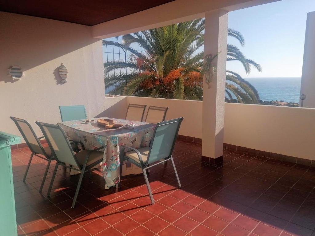 a dining room with a table and chairs and the ocean at Apartamento Mar Azul in Lagos