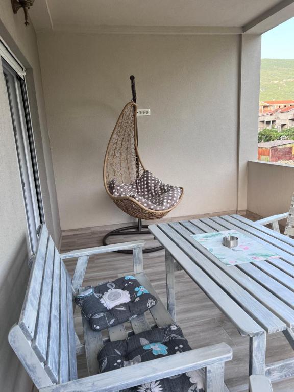 a porch with a hammock and a table and chairs at Apartmani Vivami in Budva