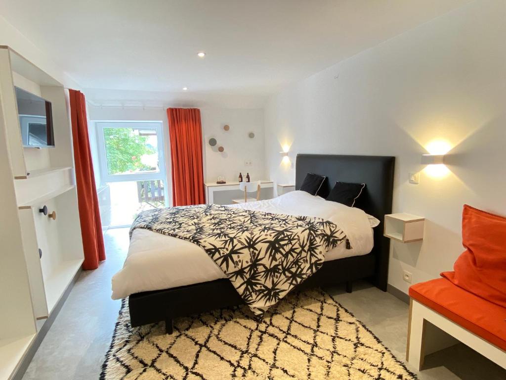 una camera con un grande letto e una finestra di Ô Macra B&B - Aubel, Pays de Herve ad Aubel